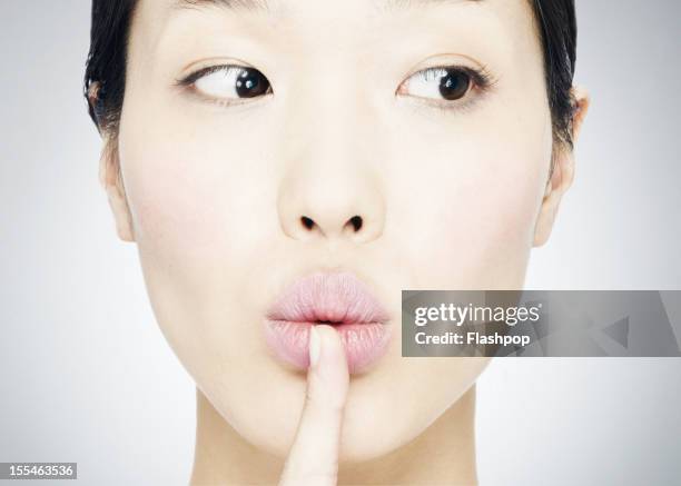 woman saying "sssh" - woman with finger on lips stock pictures, royalty-free photos & images