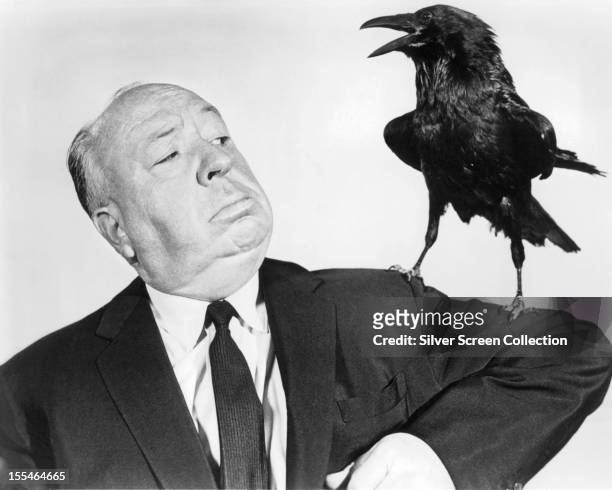English director Alfred Hitchcock poses with a stuffed crow in a promotional portrait for his film 'The Birds', 1963.