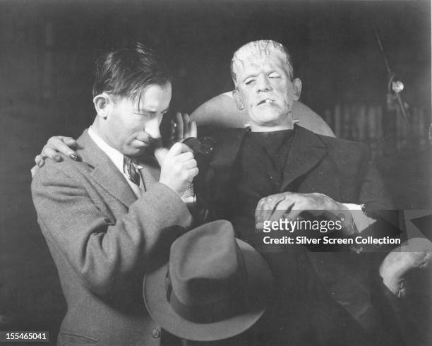 British actor Boris Karloff on the set of 'Frankenstein' with a member of the film crew, directed by James Whale, 1931.