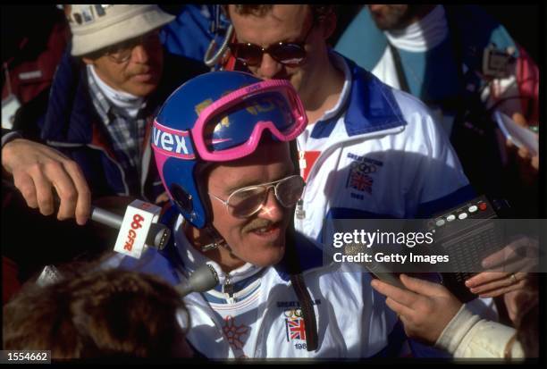 MICHAEL '' EDDIE THE EAGLE '' EDWARDS OF GREAT BRTIAIN IS MOBBED BY REPORTERS DURING THE 90 METRE SKI JUMP COMPETITION AT THE 1988 WINTER OLYMPICS....