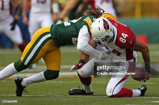 Rob Housler of the Arizona Cardinals can't hold on to the ball as he is hit by Jerron McMillian of the Green Bay Packers at Lambeau Field on November...