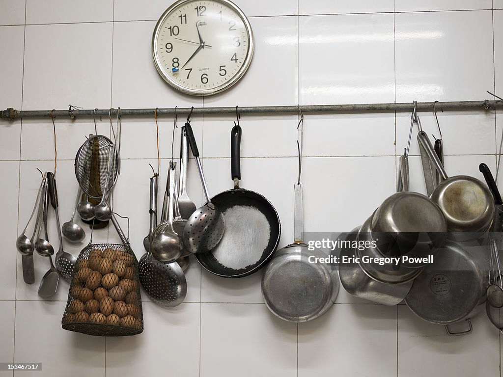 Kitchen wall with eggs, clock and pans