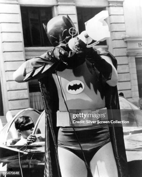 American actor Adam West as Batman in the US TV series 'Batman', circa 1967. In the background is Burt Ward as Robin.