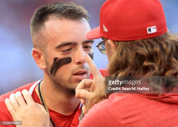 Zach Neto of the Los Angeles Angels reacts after being hit in the helmet diving back to first base in a pick off attempt during the first inning of a...