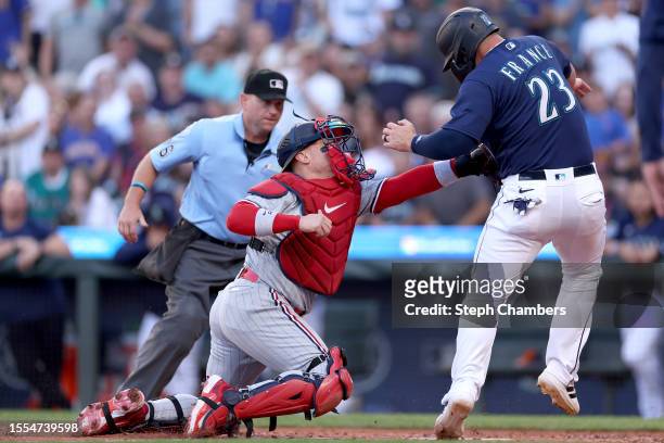 Christian Vazquez of the Minnesota Twins tags out Ty France of the Seattle Mariners during the first inning at T-Mobile Park on July 18, 2023 in...