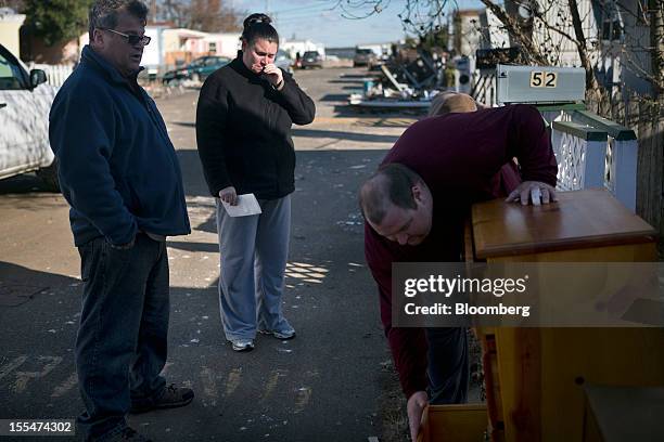 Cami Mazzarella cries while compiling a list of her belongings ruined during Hurricane Sandy for a FEMA claim, as her fiance Daniel Parker, left,...