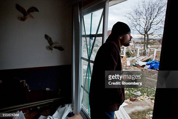 Antonio Hernandez looks out from his girlfriend's house damaged during Hurricane Sandy as debris clogs streets and yards in Union Beach, New Jersey,...