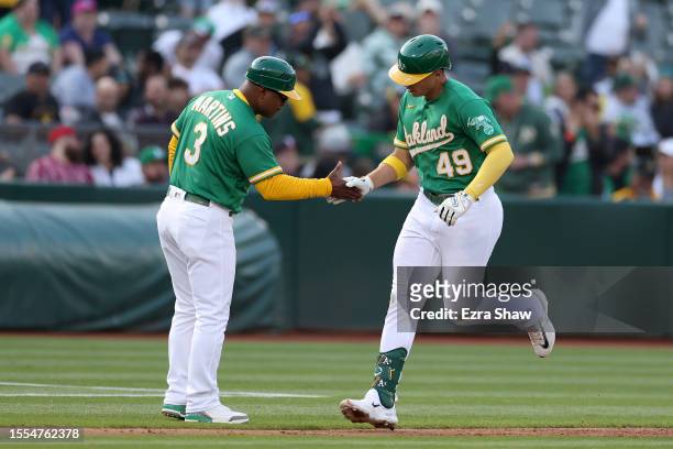 Ryan Noda of the Oakland Athletics is congratulated by third base coach Eric Martins of the Oakland Athletics after he hit a home run against the...