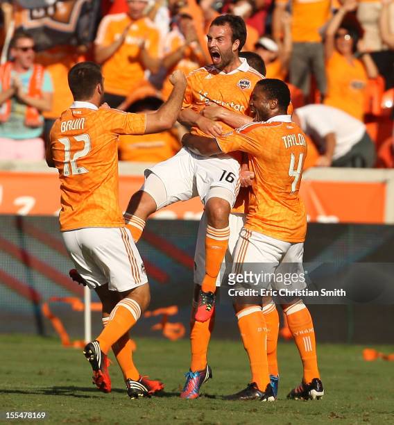 Adam Moffat of the Houston Dynamo celebrates his goal in the nineteenth minute with teammate Jermaine Taylor and Will Bruin during the first half of...