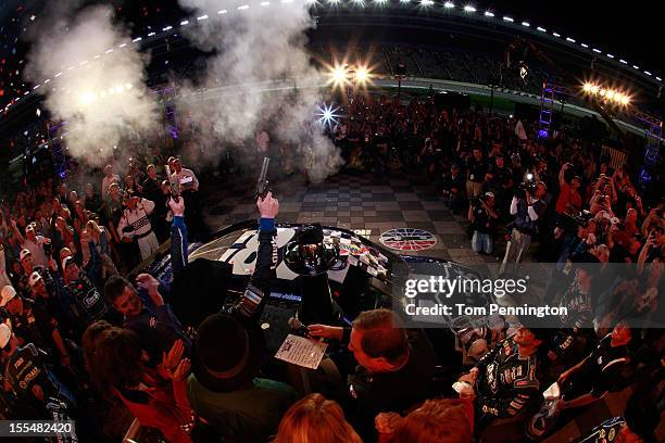 Jimmie Johnson, driver of the Lowe's Chevrolet, celebrates in Victory Lane by firing the commemorative Turnbull pistols after winning the NASCAR...