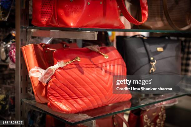 brand new designer handbags on shelves of a fashion store, out for sale - multi colored purse stockfoto's en -beelden