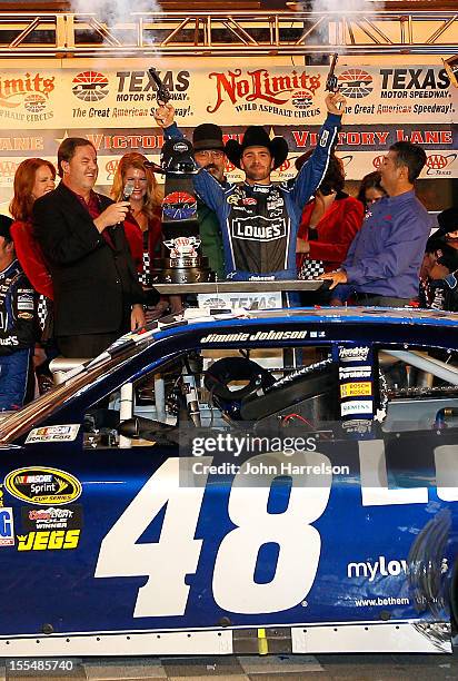 Jimmie Johnson, driver of the Lowe's Chevrolet, celebrates in Victory Lane by firing the commemorative Turnbull pistols after winning the NASCAR...