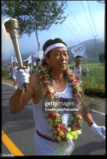 ONE OF THE OLYMPIC TORCH BEARERS MAKES HIS WAY TO THE OLYMPIC STADIUM IN SEOUL IN PREPERATION FOR THE OPENING CEREMONY OF THE 1988 SUMMER OLYMPICS IN...