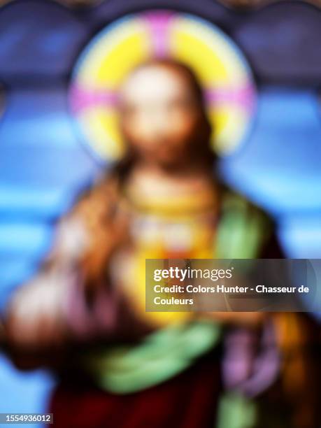 fully blurred photograph of a colorful stained glass window depicting jesus christ in combloux, haute-savoie, france - church window stock pictures, royalty-free photos & images