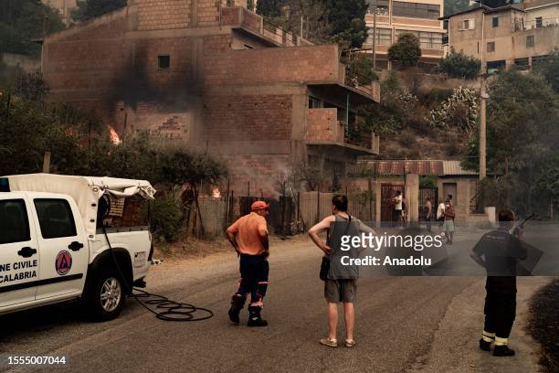 People trying to put out the fire with their own hands in Cardeto, Reggio Calabria, Italy on July 25, 2023.