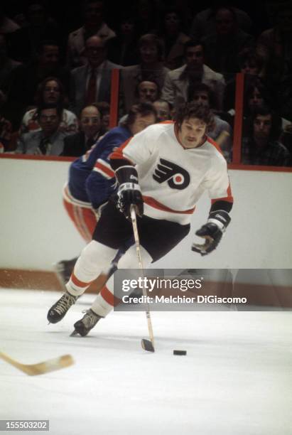 Dave Schultz of the Philadelphia Flyers skates with the puck during an NHL game against the New York Rangers circa 1972 at the Spectrum in...