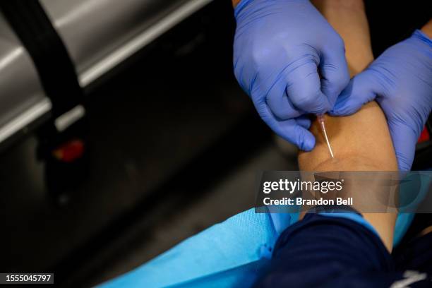 Needle is inserted into the arm of Darwin Varela in preparation to receive fluid from an IV bag after suffering from dehydration on July 18, 2023 in...