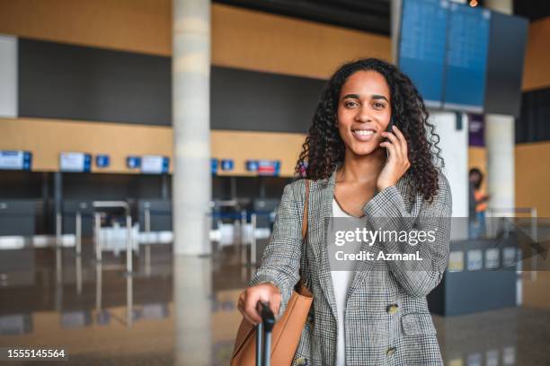 mulher adulta jovem hispânica tendo um telefonema no aeroporto - lobby - fotografias e filmes do acervo