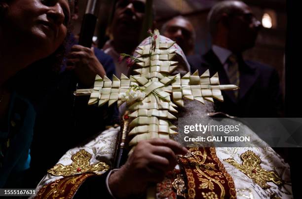 Coptic Archbishop of Jerusalem Anba Abraham holds cross-shaped palm branches as he leads the Coptic Orthodox Palm Sunday Easter procession at the...