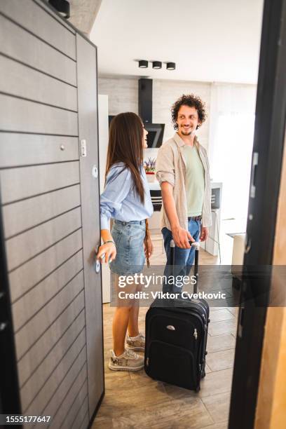 young couple on vacation walking into their hotel room - hostel people stock pictures, royalty-free photos & images