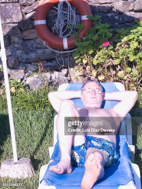 bather sunbathing in the pool. - pool umbrella top view stock pictures, royalty-free photos & images