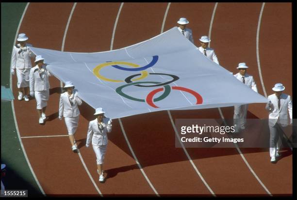 THE OLYMPIC FLAG IS CARRIED AROUND THE STADIUM TO PRESENT IT TO THE KOREAN PEOPLE DURING THE OPENING CEREMONY OF THE 1988 SEOUL OLYMPICS.