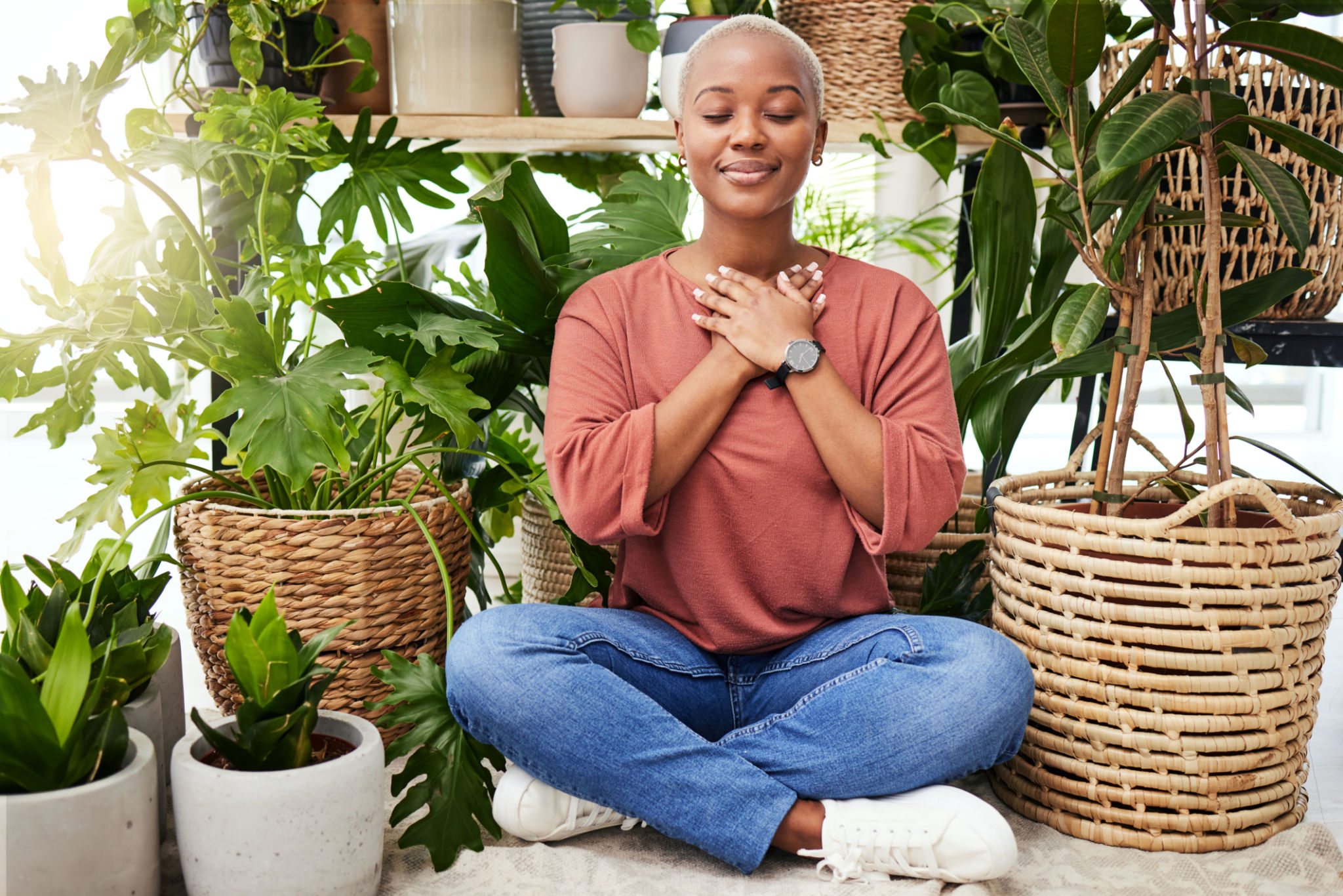 Peace, breathe and calm woman by plants for meditation exercise in a greenery nursery. Health, gratitude and young African female person with a relaxing zen mindset by an indoor greenhouse garden. Peace, breathe and calm woman by plants for meditation exercise in a greenery nursery. Health, gratitude and young African female person with a relaxing zen mindset by an indoor greenhouse garden.