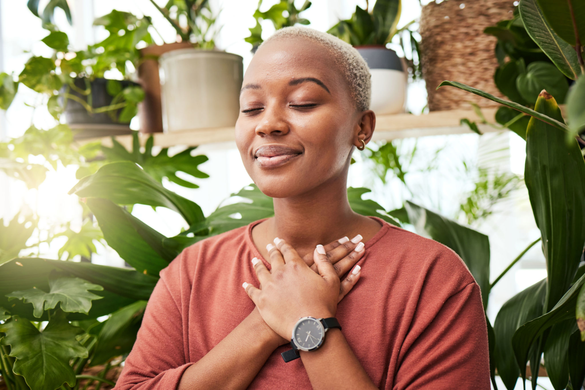 Balance, breathing and young woman by plants for zen meditation in a greenery nursery. Breathe, gratitude and young African female person with a relaxing peace mindset by an indoor greenhouse garden. Balance, breathing and young woman by plants for zen meditation in a greenery nursery. Breathe, gratitude and young African female person with a relaxing peace mindset by an indoor greenhouse garden.