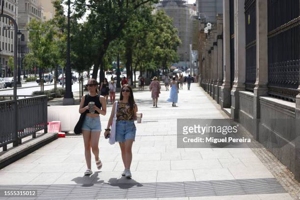 People walk down the iconic Alcalá street on a very hot afternoon on July 18, 2023 in Madrid, Spain. An area of high pressure, named Cerberus after...
