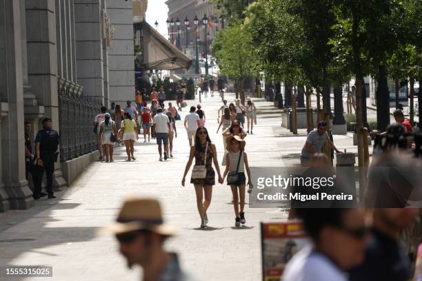 People walk down the iconic Alcalá street on a very hot afternoon on July 18, 2023 in Madrid, Spain. An area of high pressure, named Cerberus after...