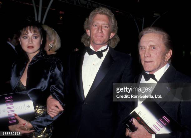 Actor Kirk Douglas and Peter Douglas attend the premiere of Scrooged on November 17, 1988 at Mann Chinese Theater in Hollywood, California.