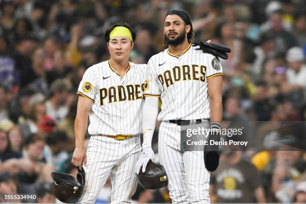 Ha-Seong Kim of the San Diego Padres, left, and Fernando Tatis Jr. #23 stand on the mound during a pitching change in the fifth inning of a baseball...