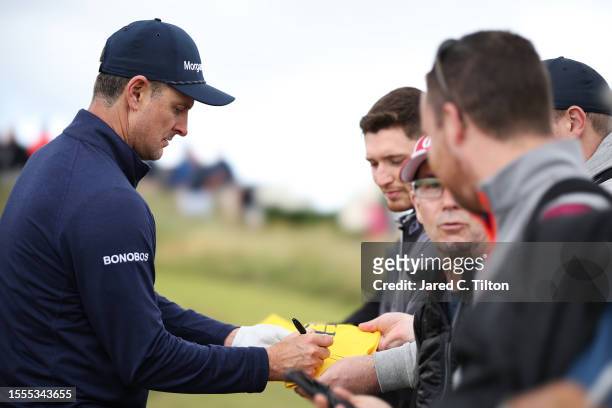 Justin Rose of England signs his autograph on the 14th hole during a practice round prior to The 151st Open at Royal Liverpool Golf Club on July 19,...