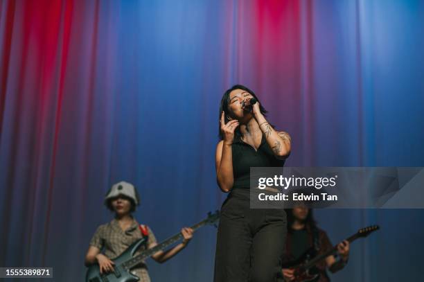 young asian chinese lead singer and live band multiracial group performance on stage - electronic music production stock pictures, royalty-free photos & images