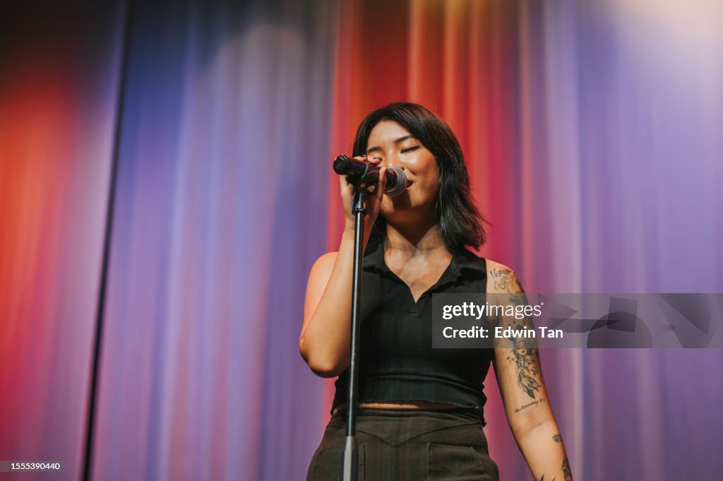 Joven chino asiático Cantante femenina solista cantando en el escenario