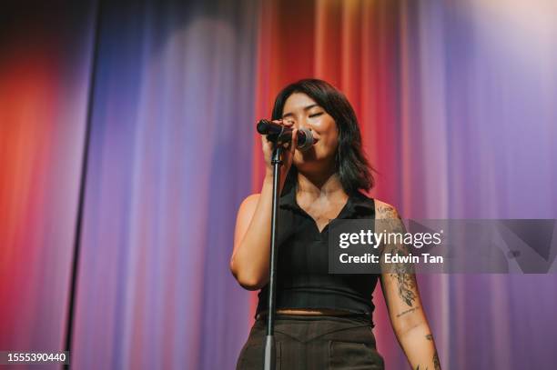 young asian chinese solo female singer singing performance on stage - solo performance stockfoto's en -beelden