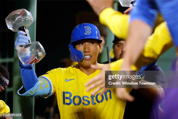 Masataka Yoshida of the Boston Red Sox is congratulated in the dugout after his two-run home run against the Atlanta Braves during the eighth inning...
