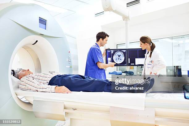 médicos analizar una tomografía axial computerizada - mri machine fotografías e imágenes de stock