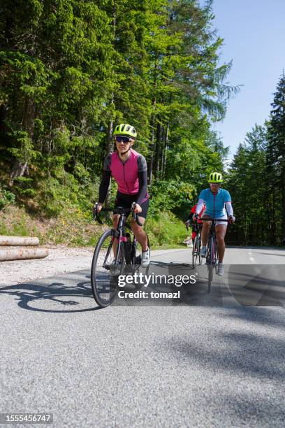 female friends cycling - mountain road stock pictures, royalty-free photos & images