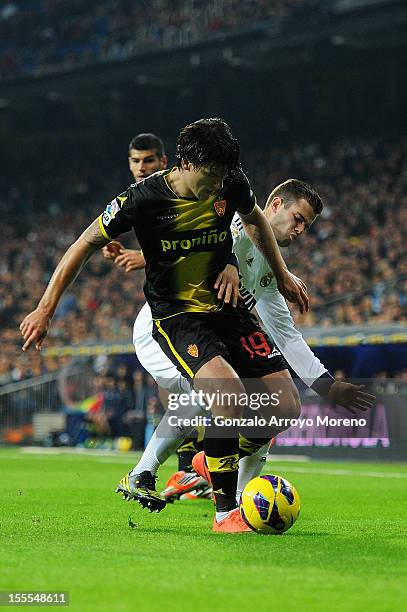 Nacho Fernandez of Real Madrid CF competes for the ball with Cristian Sapunaru of Real Zaragoza during the La Liga match between Real Madrid CF and...