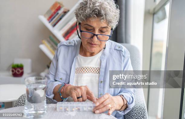 senior frau unter einer pille - tablettenschachtel stock-fotos und bilder