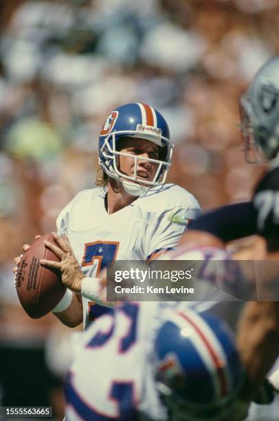 John Elway, Quarterback for the Denver Broncos prepares to throw the football downfield during the American Football Conference West Division game...