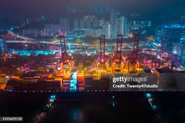 aerial view of cranes loading containers into the ship at hong kong commercial port - docklands studio stock pictures, royalty-free photos & images