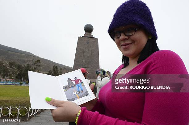 Tourist shows a picture of herself in front of the "Middle of the world" monument, in Quito, Ecuador, on November 5, 2012. The world's tallest tower,...