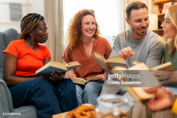 group of women and men attending a book club meeting - book club meeting stockfoto's en -beelden