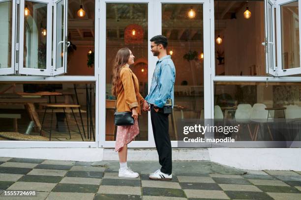 jeune couple aimant debout face à face devant un café - romantic cafe photos et images de collection