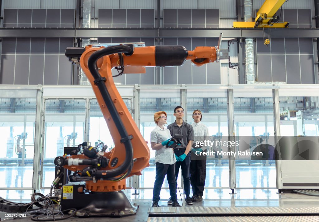 Apprentice Engineers With Robot In Factory High-Res Stock Photo - Getty ...