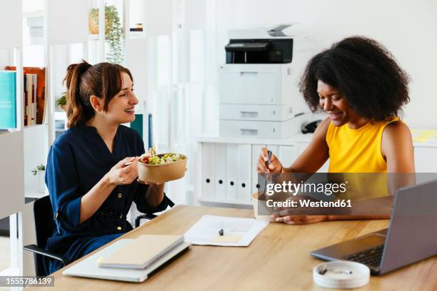 multiracial colleagues eating lunch in office - worker lunch stock-fotos und bilder