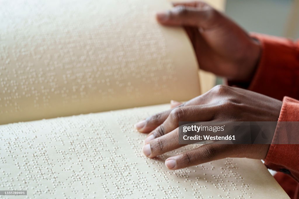 Hand of woman reading text from braille