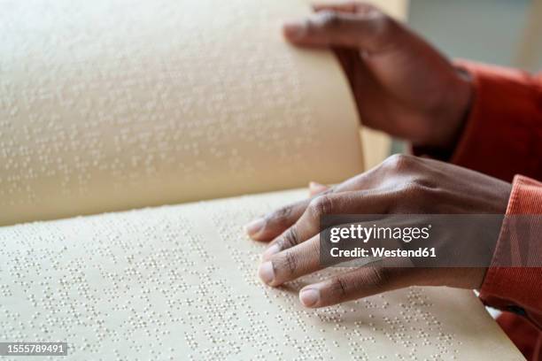 hand of woman reading text from braille - braille stock pictures, royalty-free photos & images